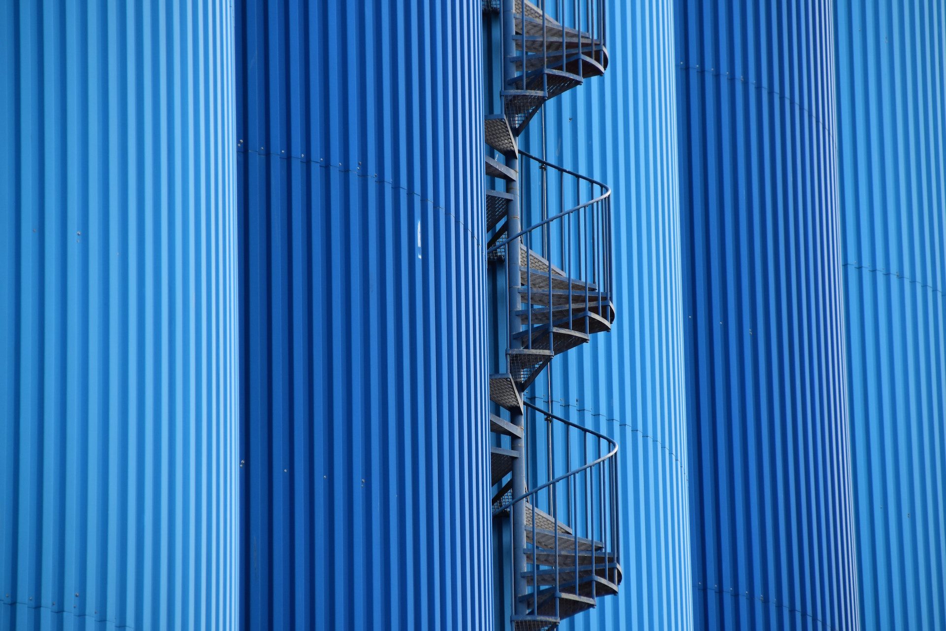 close up of a blue building with spiral staircase