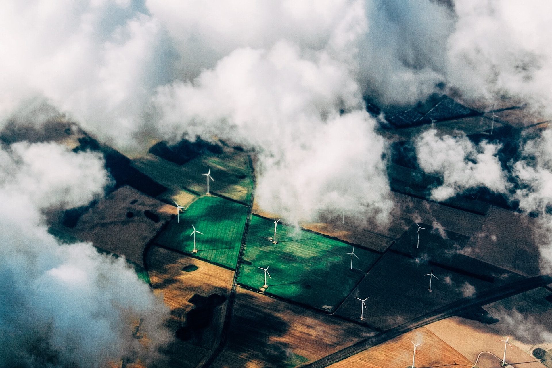 birds eye view of clouds with wind turbines in a wind farm