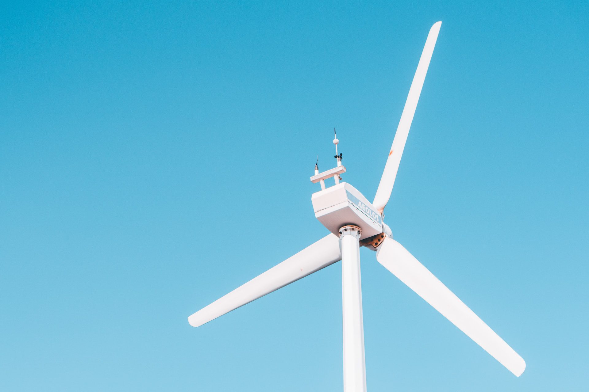 close up of wind turbine with blue sky behind