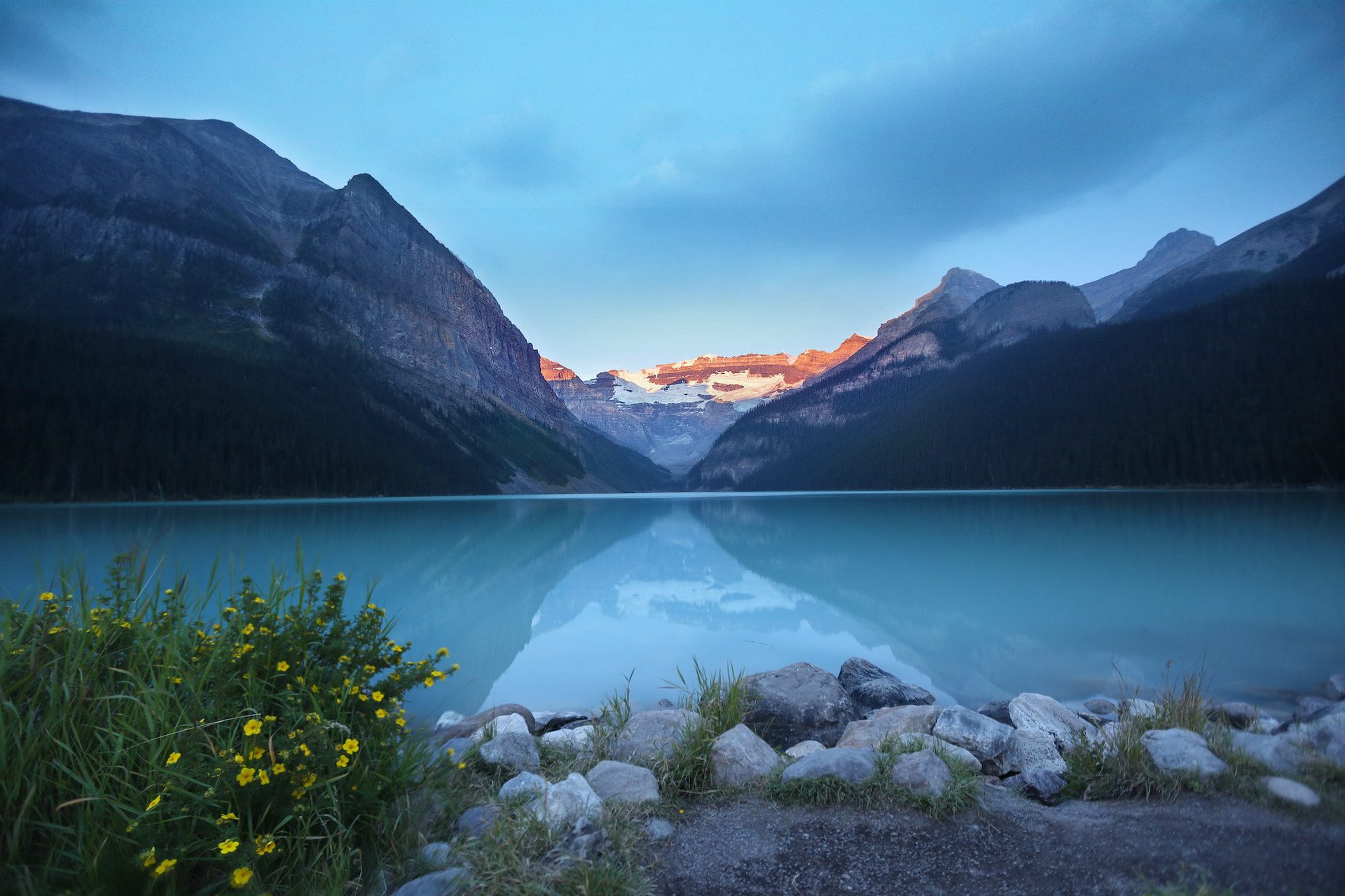 lake with mountain in the background and stones in the foreground