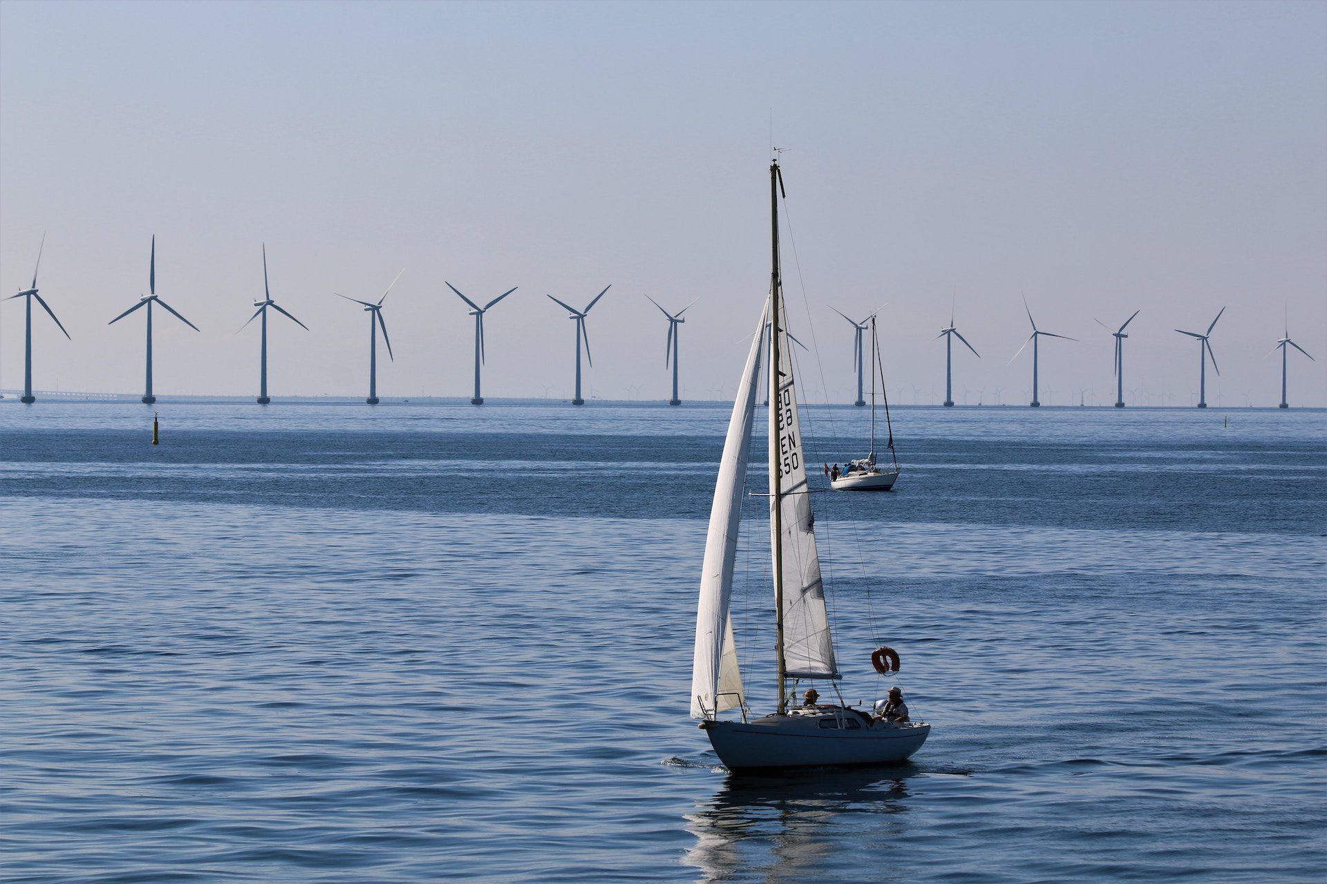 boat on ocean with wind turbines in the background